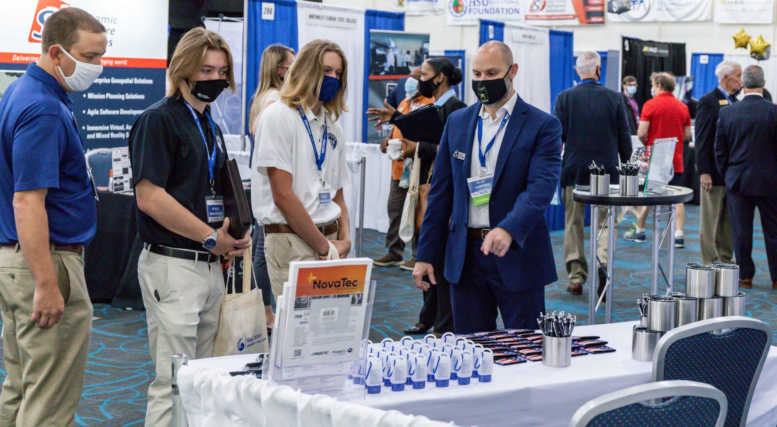 TeCMEN Booth with a Small Crowd Conference booth with display and visitors for TeCMEN Industry Day