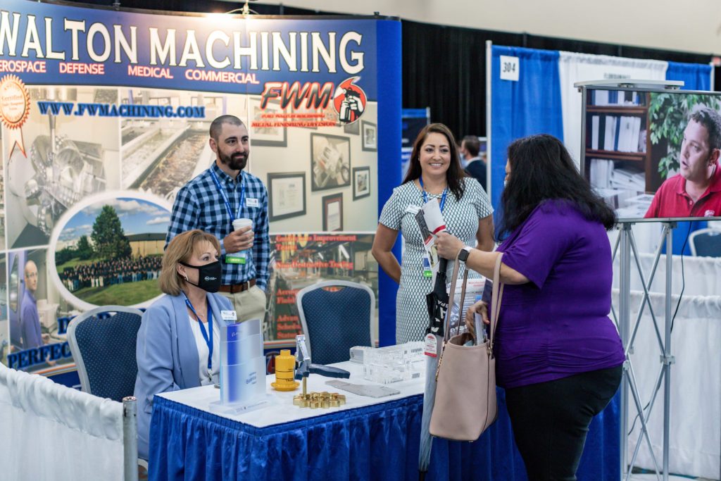 TeCMEN Booth with Visitors-2 A conference booth with visitors for TeCMEN Industry Day