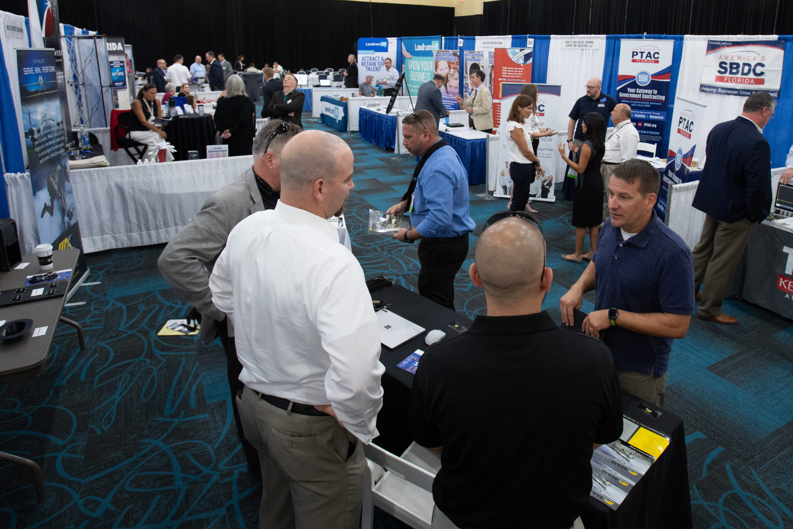 TeCMEN Technical Showcase 2 men at a conference booth at the TeCMEN Industry Day